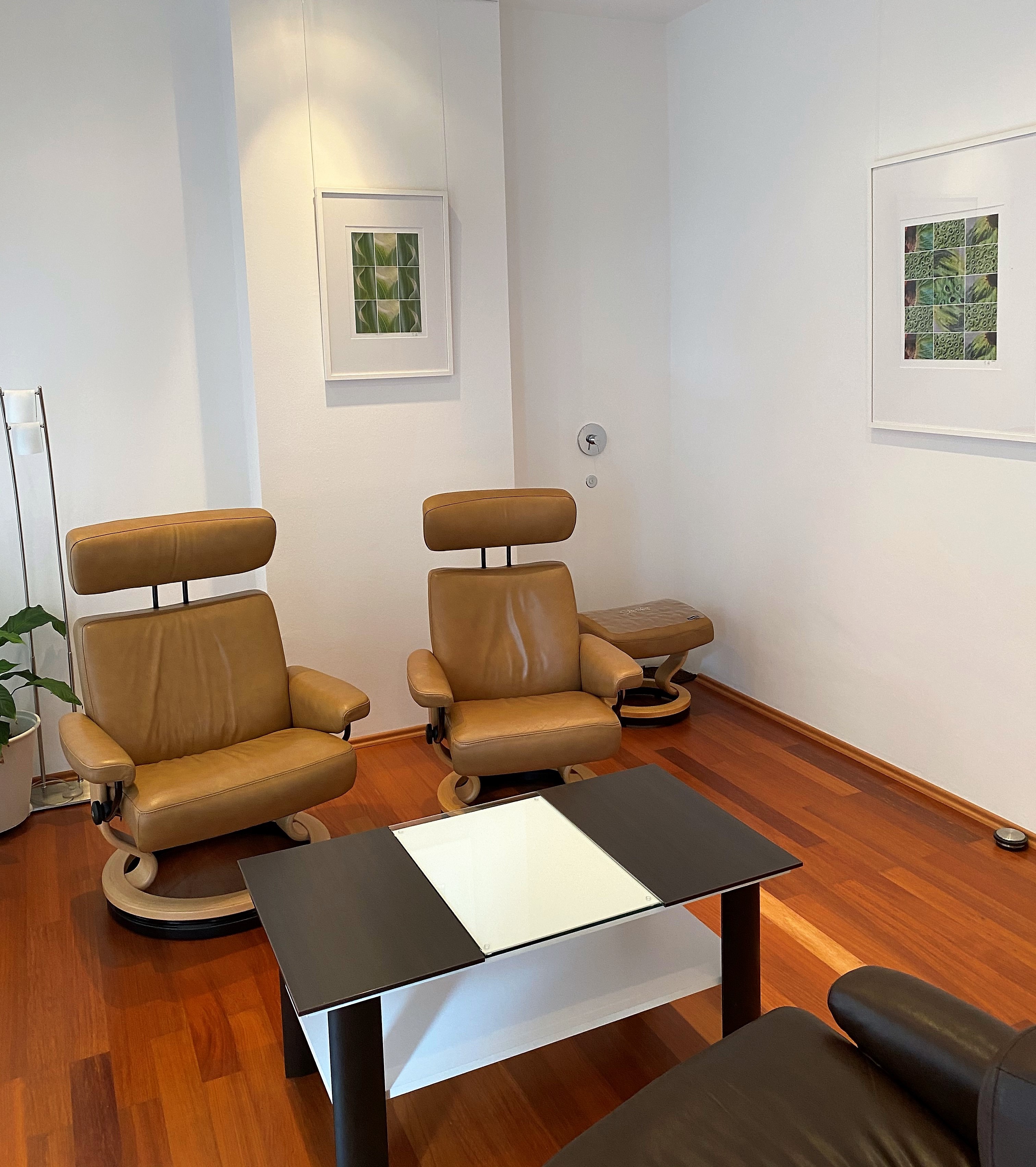 Gesprächszimmer mit Ledersesseln und Glastisch